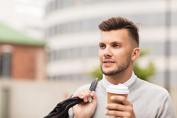 Image showing young man with bag drinking coffee in city