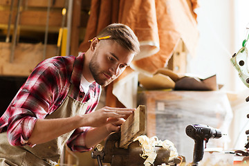 Image showing carpenter working with wood plank at workshop