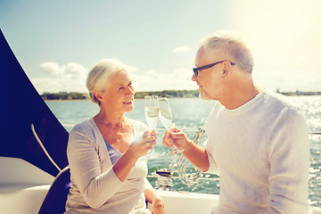 Image showing senior couple clinking glasses on boat or yacht