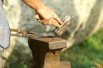 Image showing black smith make with forge hammer an arrow