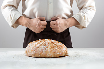 Image showing The male hands and rustic organic loaf of bread