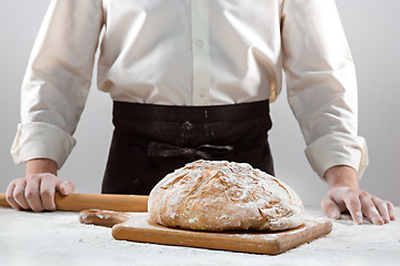 Image showing The male hands and rustic organic loaf of bread