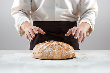 Image showing The male hands and rustic organic loaf of bread