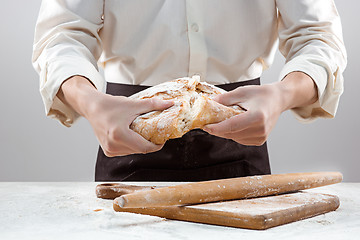 Image showing Baker man holding rustic organic loaf of bread in hands