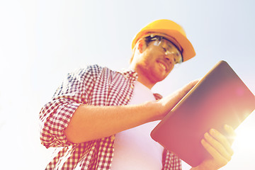 Image showing close up of builder in hardhat with tablet pc