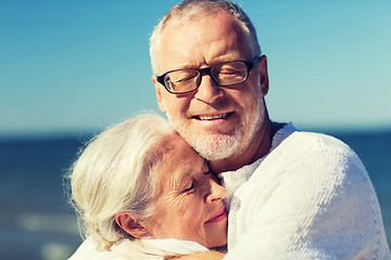 Image showing happy senior couple hugging on summer beach