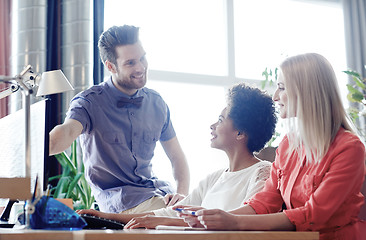 Image showing happy creative team with computer in office