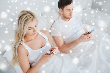 Image showing couple with smartphones in bed