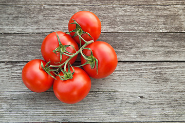 Image showing Dewy red tomatoes on the rustic wood