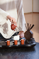 Image showing Young man holds a Chinese tea ceremony
