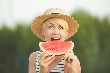 Image showing Beautiful girl in straw hat eating fresh watermelon. Film camera style