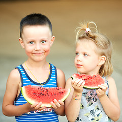 Image showing Young girl and boy eating watermelon