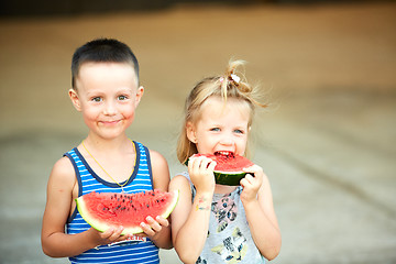 Image showing Young girl and boy eating watermelon