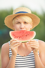 Image showing Beautiful girl in straw hat eating fresh watermelon. Film camera style