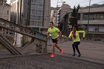 Image showing young multiethnic couple jogging in the city