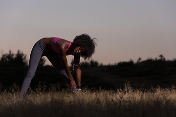 Image showing black woman is doing stretching exercise relaxing and warm up