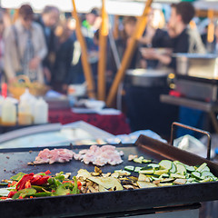 Image showing Chef making chicken with grilled vegetable tortilla wrap outdoor on street stall.