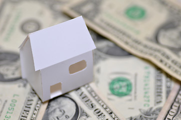 Image showing Miniature paper made house stand on  money