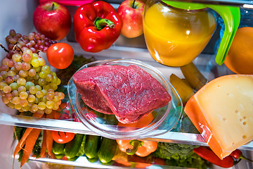 Image showing Fresh raw meat on a shelf open refrigerator