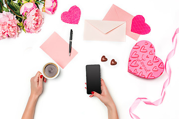 Image showing The female hands with phone and gift box on white background