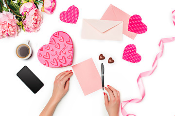 Image showing The female hands with pen and gift box on white background