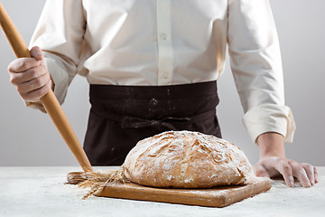 Image showing The male hands and rustic organic loaf of bread