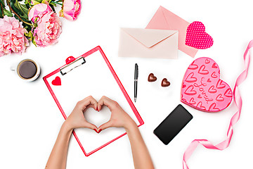 Image showing The female hands making heart and gift box with hearts on white background