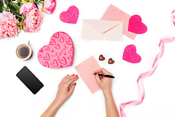 Image showing The female hands with pen and gift box on white background