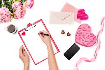 Image showing The female hands with pen and gift box on white background