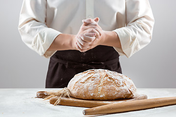 Image showing The male hands and rustic organic loaf of bread