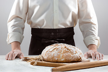 Image showing The male hands and rustic organic loaf of bread