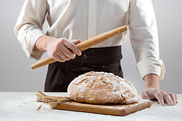 Image showing The male hands and rustic organic loaf of bread