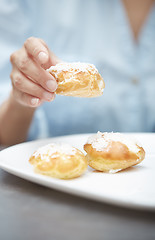 Image showing Woman eating eclairs