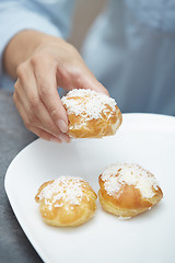 Image showing Woman eating eclairs