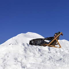 Image showing Skier at winter mountains resting on sun-lounger in outdoor cafe