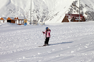 Image showing Little skier at ski resort in sun winter day