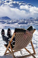 Image showing Skier at winter mountains resting on sun-lounger