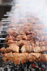 Image showing Grilling marinated shashlik on a grill. Shish kebab popular in Eastern, Central Europe and other places. 