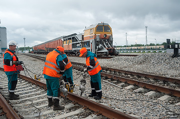 Image showing Railway workers repairing rail