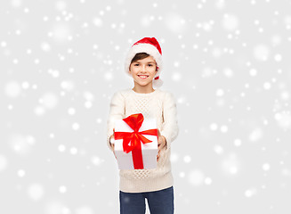 Image showing smiling happy boy in santa hat with gift box