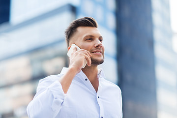 Image showing happy man with smartphone calling on city street