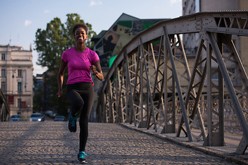 Image showing african american woman running across the bridge