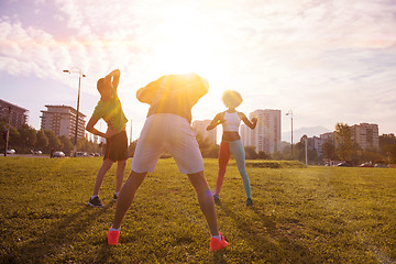 Image showing multiethnic group of people stretching in city park