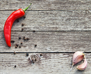 Image showing Red hot chili peppers with garlic on wood