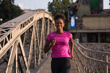 Image showing african american woman running across the bridge