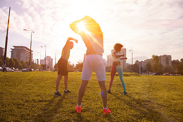 Image showing multiethnic group of people stretching in city park