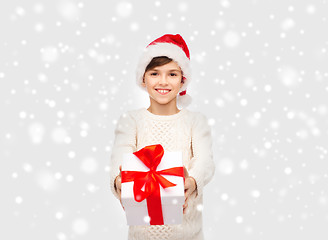 Image showing smiling happy boy in santa hat with gift box