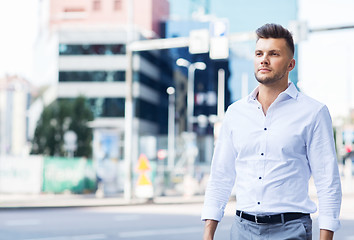 Image showing young man walking along city street