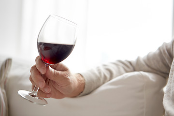 Image showing close up of hand holding glass with red wine