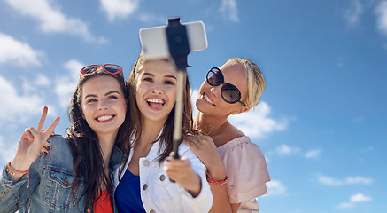 Image showing group of smiling women taking selfie over blue sky
